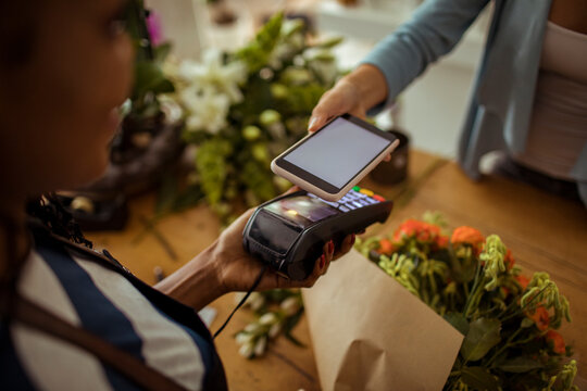 Close up of a customer paying with a smartphone in a flower store