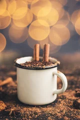 Schilderijen op glas Homemade spicy hot chocolate drink with cinnamon stick, star anise, grated chocolate in enamel mug on dark background with cookies, cacao powder and chocolate pieces, Christmas lights bokeh © O.Farion