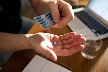 Close up male hands holding pill with medication packaging