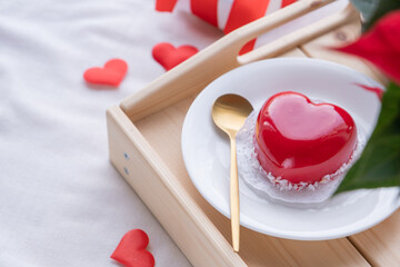 heart shaped glazed valentine cake in bed on wooden tray