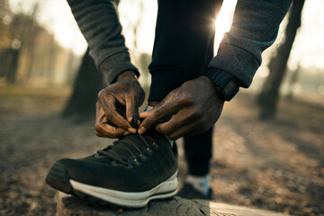 Man tying fitness shoes for outdoor run in park