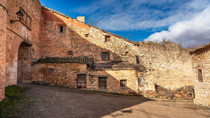 Old houses and stone arch in the wall surrounding the picturesque village of Palazuelos, Spain.