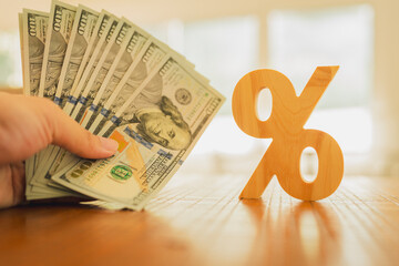 Percent symbol with people holding money that is many dollar bills. Concepts of the banking system,...