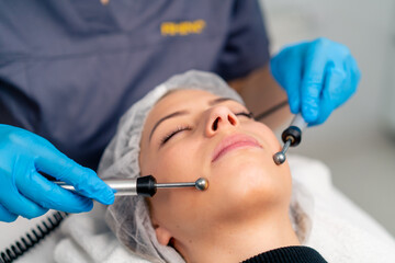 Naklejka premium close-up of a beautician doctor massaging the skin of a client's face during a beauty and health cosmetic procedure
