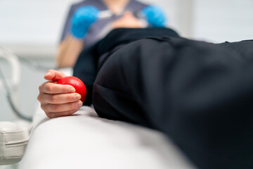 close-up of a woman's hand squeezing an anti-stress ball toy during a painful cosmetic procedure in a beauty salon