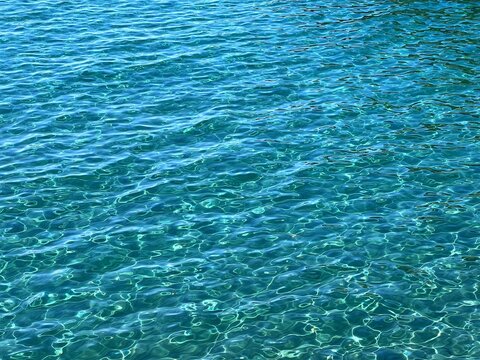 Blue sea water calm clear surface ripples.
