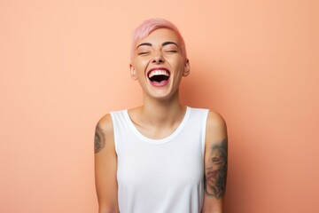 Portrait of happy cute girl with pink hair and tattooed hands, standing over pink background,...