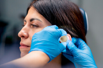 close-up ENT doctor examines the patient's ears in the office of the clinic with professional...