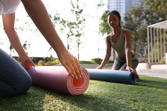 A couple young woman with sport uniform prepare yoga mats at the poolside, Yoga exercise