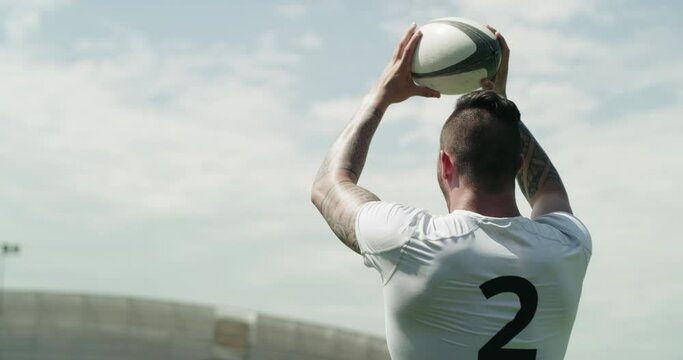 Rugby, throw and man with ball on field for game, match or practice workout with cloudy sky from back. Fitness, sports club and strong athlete playing at competition, challenge or exercise at stadium
