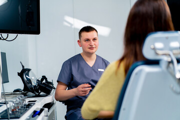 the ENT doctor consults the patient in the office of the clinic and tells about the possible...
