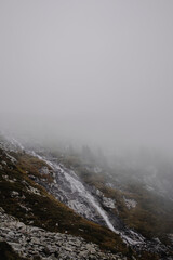 High in the cradle of majestic mountains, a pristine water source emerges, a testament to nature's artistry.