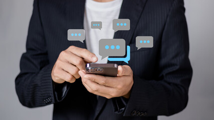 Social media maketing concept. Man using smartphone to chat online with chat box icon appearing..