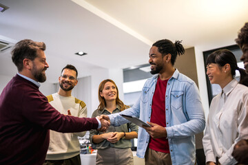 Multiethnic colleagues meeting their new associate in their modern office.