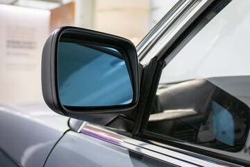 Close-up of a metal mirror of a modern car. Automotive transport or automobile industry concepts. View with copy space