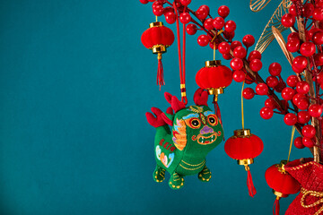 A New Year's toy in the shape of a green dragon hangs on a branch tree. Festive background. Chinese...