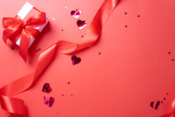 valentine red ribbons, confetti and gifts on red background