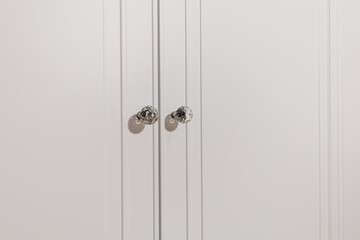 Modern Elegance: Close-Up of Crystal Handles on White Cabinet
