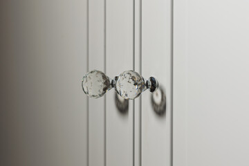 Crystal Elegance: White Cabinet Close-Up with Shiny Handles