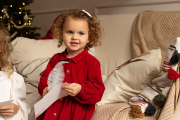 Merry Christmas. Cute little child girl writes letter to Santa Claus.