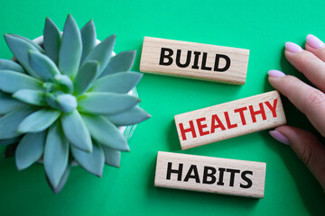 Healthy habits symbol. Concept word Build Healthy habits on wooden blocks. Doctor hand. Beautiful...