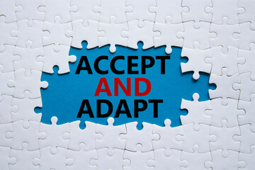 Accept or adapt symbol. Concept words Accept and adapt on white puzzle. Beautiful blue background....