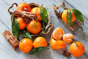 Tangerines mandarin fruit in a dish and on a wooden table, cinnamon and anise, sleigh decor. Christmas card.