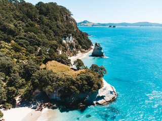 Drone photo above Cathedral Cove in New Zealand showing beaches, different rock formations, flora and fauna.