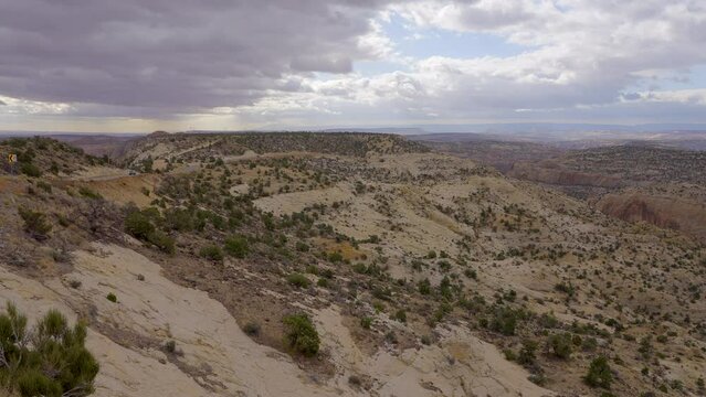 Establishing shot of brown mountains with green forest in The Hogback Scenic Root 12, Utah, North America. Day time on October 2023. ProRes 422 HQ.