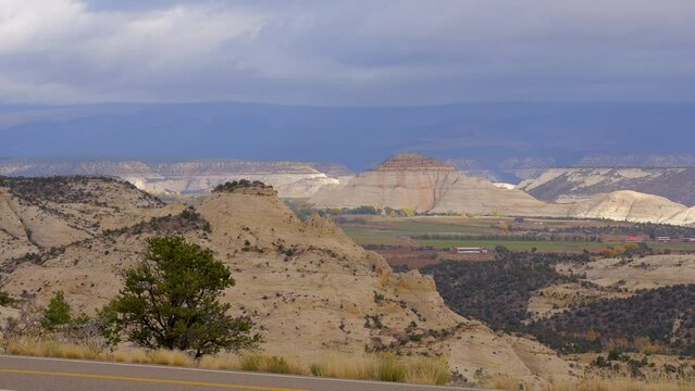 Establishing shot of brown mountains with green forest in The Hogback Scenic Root 12, Utah, North America. Day time on October 2023. ProRes 422 HQ.