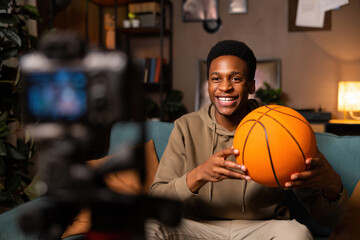 A basketball player-blogger in a cozy room, surrounded by books and basketball memorabilia, sharing...