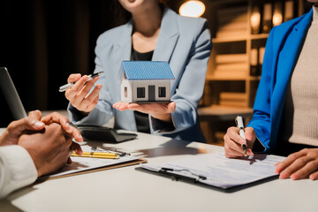 Home buyers meet and negotiate with real estate agents about renting or buying a home in the office.
