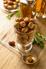 Spicy olives and bottles of olive oil on a wooden table.