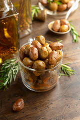 Spicy olives and bottles of olive oil on a wooden table.