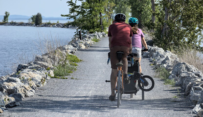 people riding a bike on the colchester causeway gravel bike path in burlington, vermont (mountain...