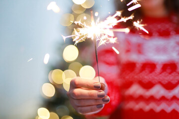 Young woman holding sparkler