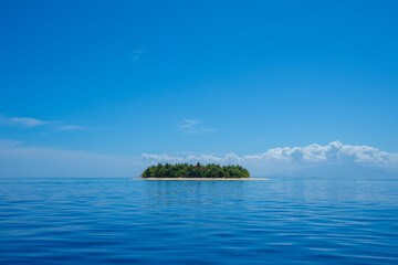 A small island in Fiji on a clear blue sky day in the South Pacific