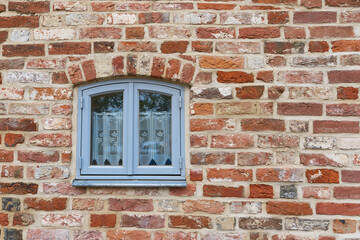 historische Fassade aus gemauerten Ziegelsteinen und einem Fenster in der Altstadt von Stralsund in...