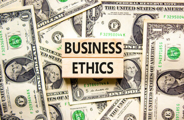 Business ethics symbol. Concept words Business ethics on beautiful wooden blocks. Dollar bills....
