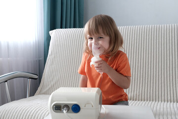 A little girl, a child of European appearance, blond hair, sits in an inhaler mask. Treatment of...