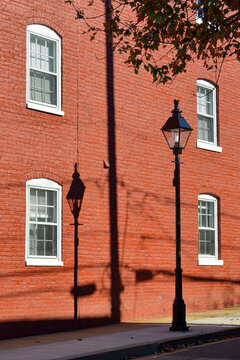 Shadow of a once gas lamp on a red painted wall on Frederick Street in the historic district of Fredericksburg Virginia