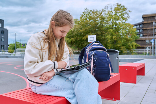 Serious schoolgirl child with backpack digital tablet outdoor