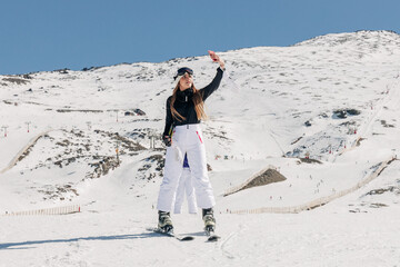 Female skier taking selfie on snowy hill