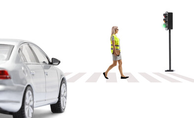 Woman with a safety vest and books walking in front of a car at pedestrian zebra sign