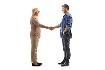 Full length profile shot of middle aged woman and a younger man shaking hands