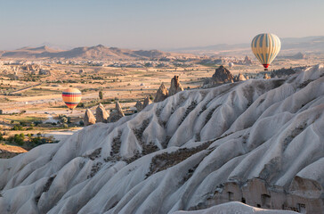 hot air balloons over the fairy chimneys and wave like eroded rock formation, Göreme, Cappadocia,...