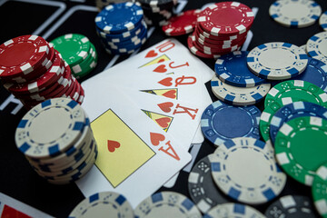 The winning combination  Royal flush with chips at casino table