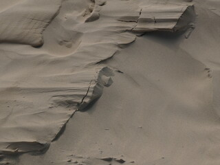 Abstrakte und bizarre Sandformen vom Wind auf einer Wanderdüne