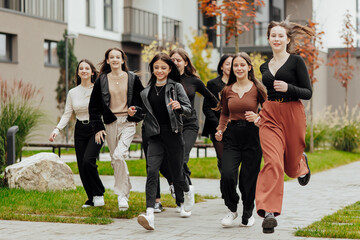 Fototapeta premium Group of many happy teenagers dressed in casual clothes having fun and having fun near college. Concept of friendship, moments of happiness. School friendship