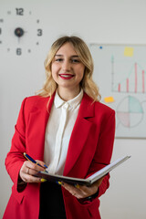 Businesswoman standing near a chartboard and working on business plan company development in office
